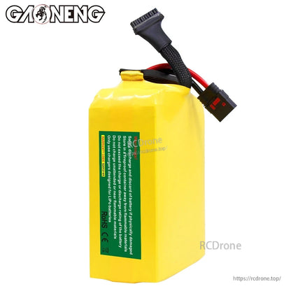 Rear view showing safety/compliance label on yellow battery pack and attached power leads