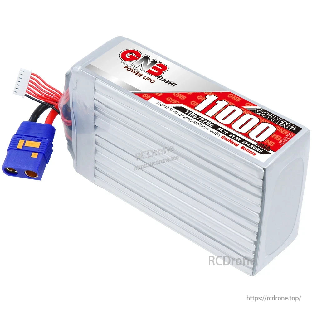 Angled top view of GNB 11000 LiPo showing ribbed silver casing, QS8 connector, and balance lead