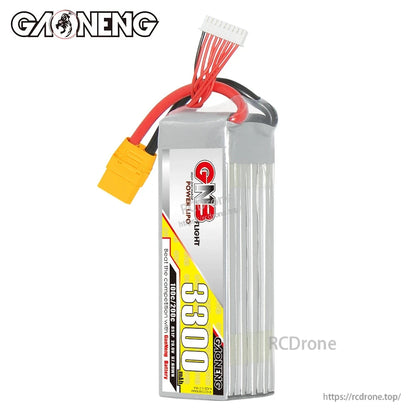 Side view of GNB 3300mAh LiPo battery showing stacked cell profile, leads and yellow XT90 plug