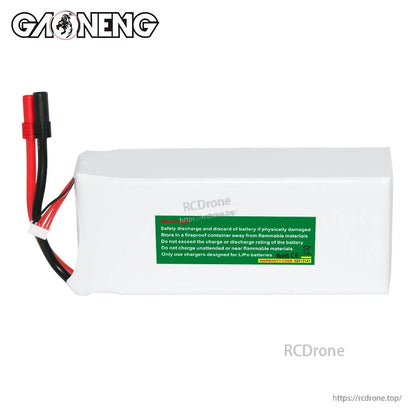 Rear view of battery with green safety warning label on white shrink wrap