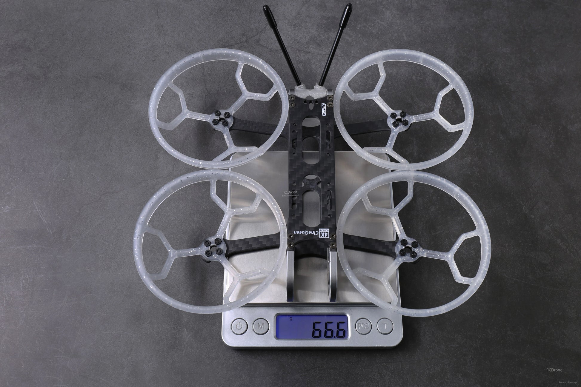 GEPRC GEP-CQ 3-inch FPV frame with four prop guards and antennas on a digital scale reading 66.6 g