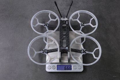 GEPRC GEP-CQ 3-inch FPV frame with four prop guards and antennas on a digital scale reading 66.6 g