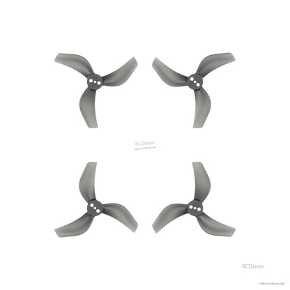 Set of four grey three-blade drone propellers with three-hole hubs, arranged on a white background