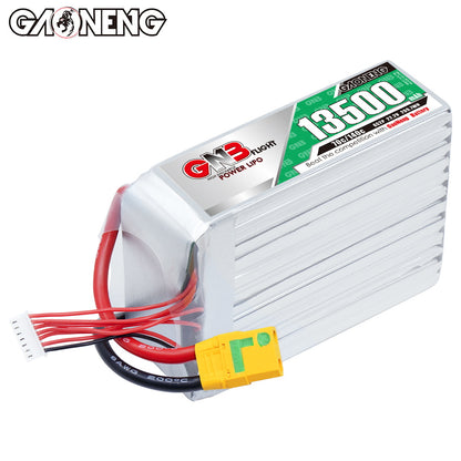Angled top view of GNB 13500mAh battery showing silver case fins, label, XT90S plug, and balance lead