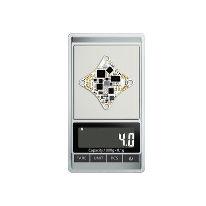 Flywoo GOKU F405 ERVT AIO flight controller board on a digital scale reading 4.0 g, with labeled solder pads
