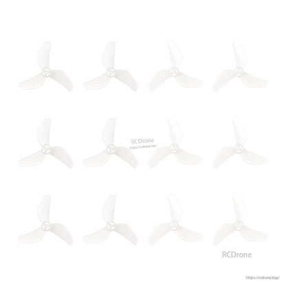 Multiple clear 3-blade micro drone propellers laid out in a grid, showing several identical props