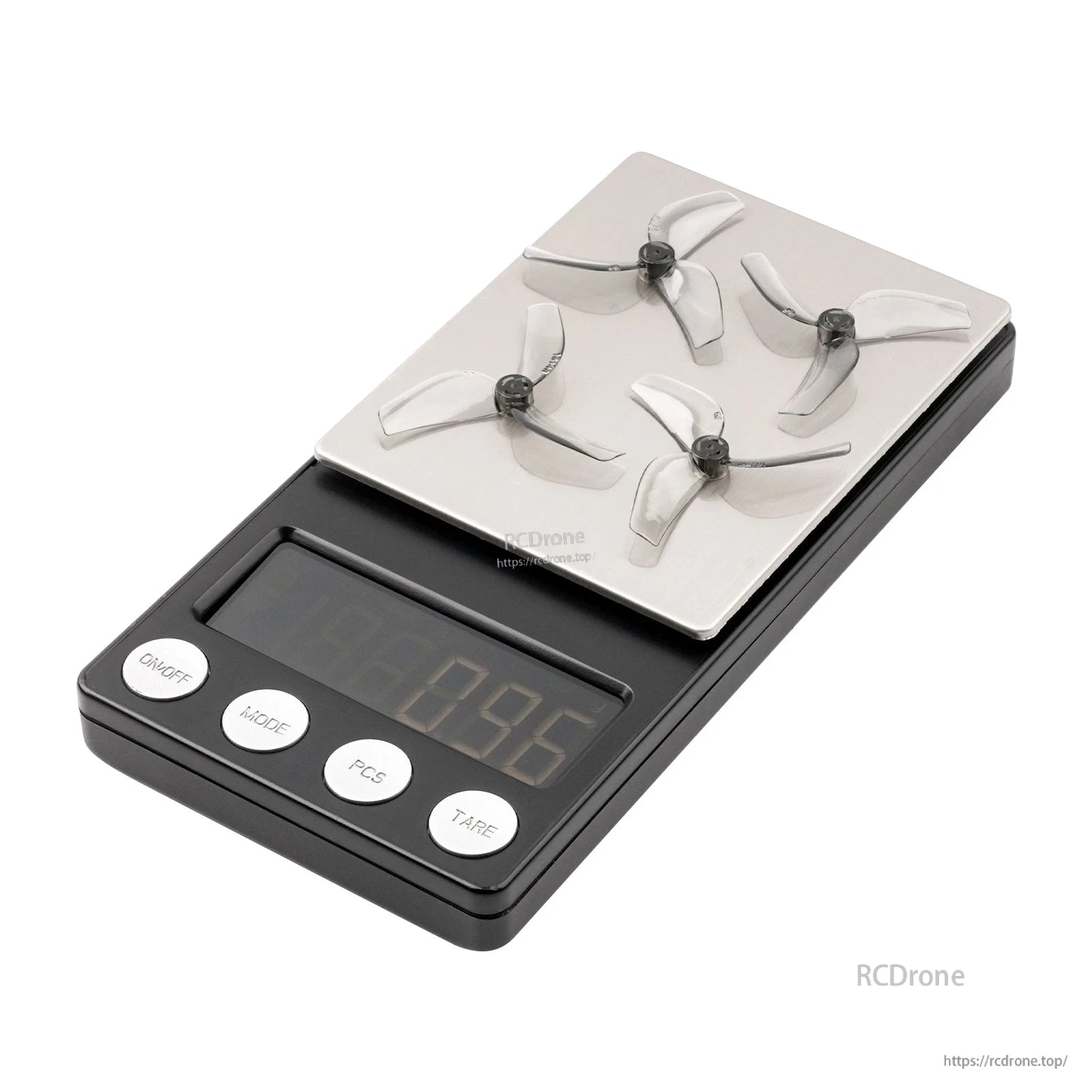 Four clear tri-blade props on a digital scale, showing weight measurement for the propeller set