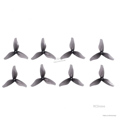 Eight translucent smoke gray 3-blade 2-inch drone propellers displayed in rows on white