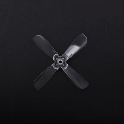 Black 4-blade propeller with 3-hole/square mounting hub, close-up on dark background