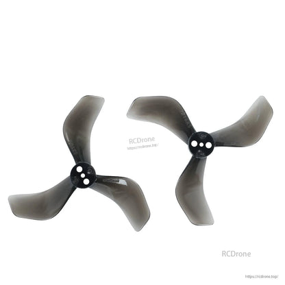 Two clear black tri-blade propellers showing opposite rotation (CW and CCW) hub orientation
