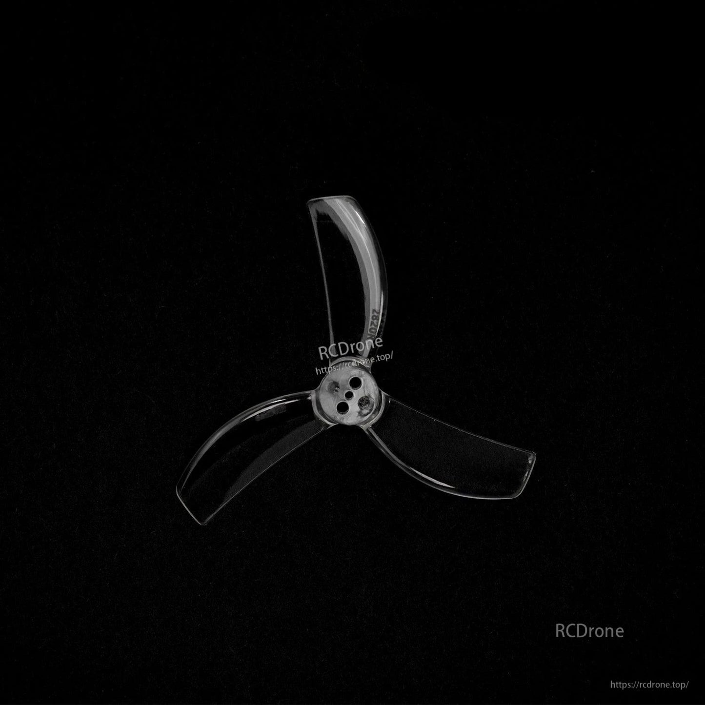 Single transparent 3-blade propeller on black background, close-up of center hub and holes