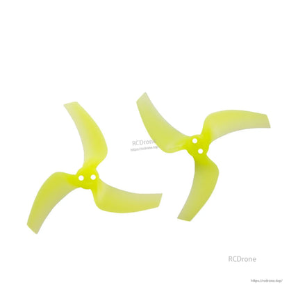 Two neon yellow tri-blade props shown as a pair, top view with dual mounting holes visible