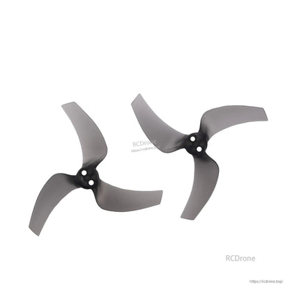 Two clear gray tri-blade propellers displayed as a pair, hub and blade shape detail