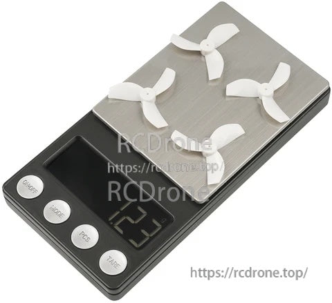 Four Gemfan 35mm 3-blade props on a digital scale showing total weight around 1.23g per 4-piece set