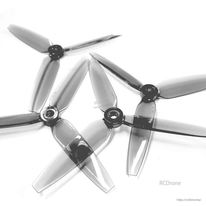 Set of four translucent gray 3-blade propellers grouped together, close view of hubs and blades