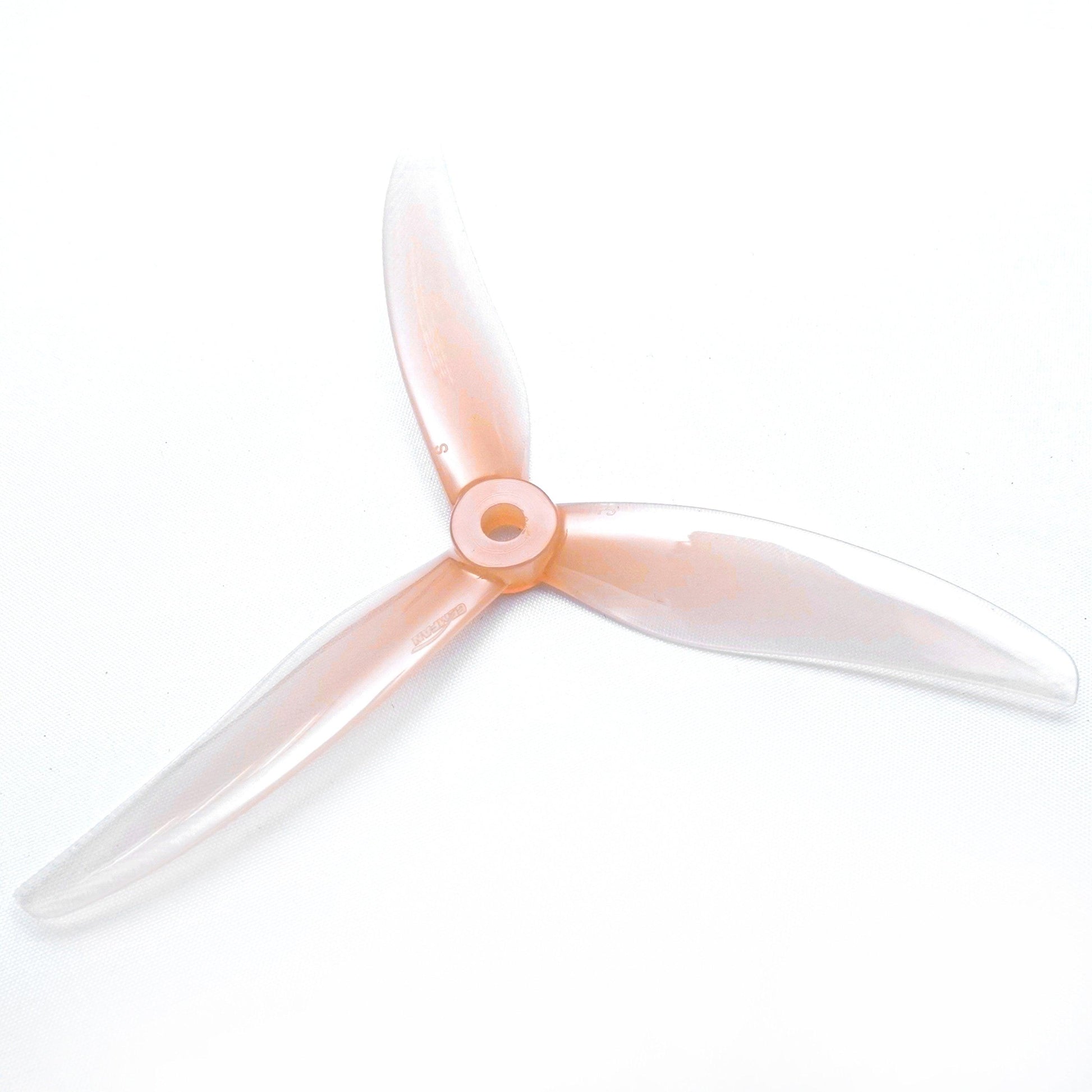 Clear light pink 3-blade FPV propeller, top view showing translucent blades and hub detail