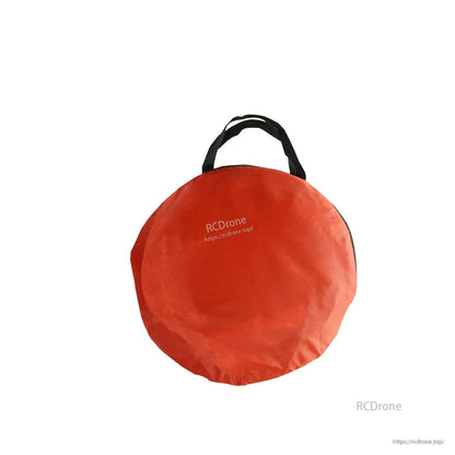 Round red carry bag with black handle for transporting the gate panels