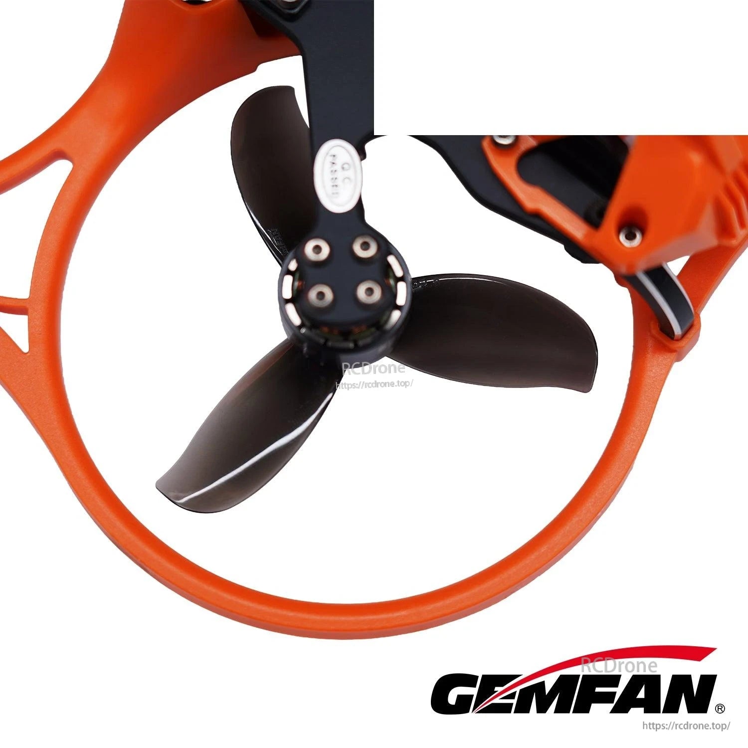 Black 3-blade prop installed in orange duct on cinewhoop frame, close-up view