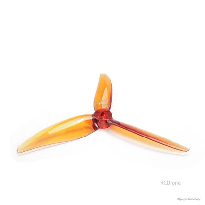 Orange 3-blade drone propeller angled view, translucent blades with red hub