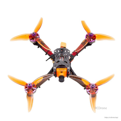 FPV quadcopter with four translucent orange 3-blade propellers installed, top-down view