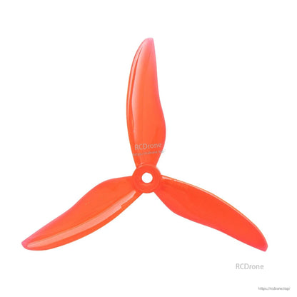 Translucent orange 3-blade drone propeller with center mounting hole, top view