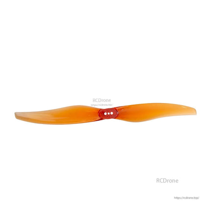 Orange two-blade propeller shown straight-on, hub with three mounting holes