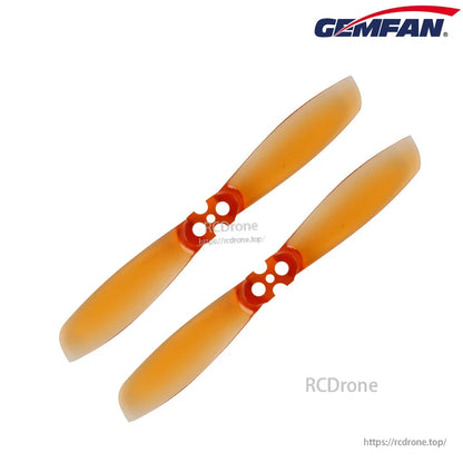 Pair of translucent orange two-blade propellers with 4-hole mounting hub, angled view