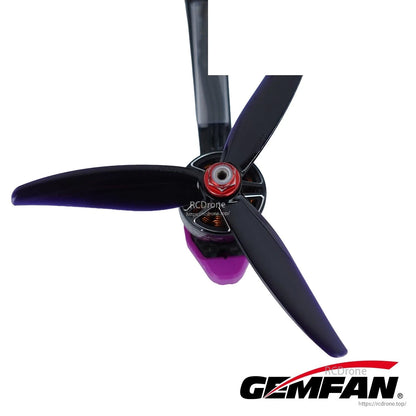 Black 3-blade FPV propeller mounted on motor, close-up of center hub