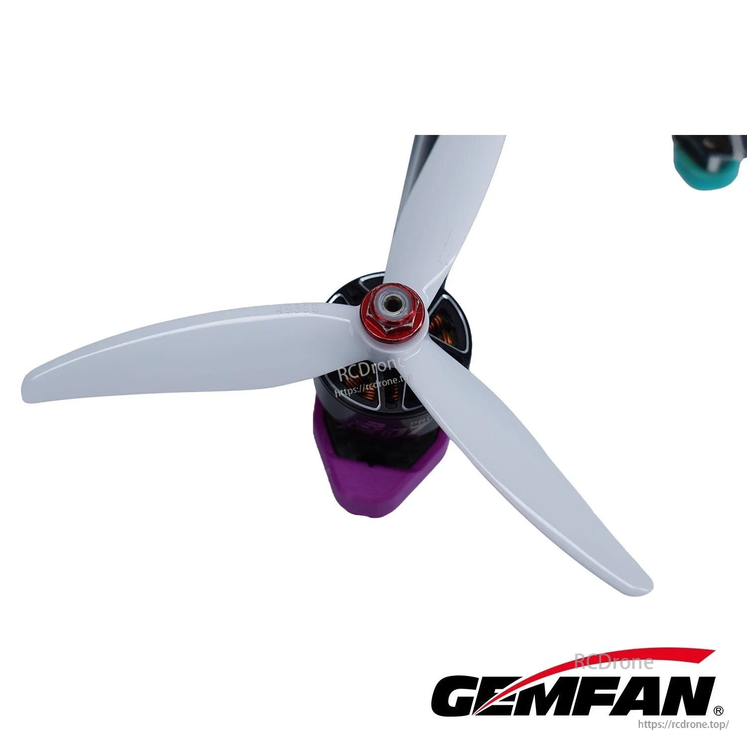 White 3-blade FPV propeller mounted on motor, close-up showing blade shape