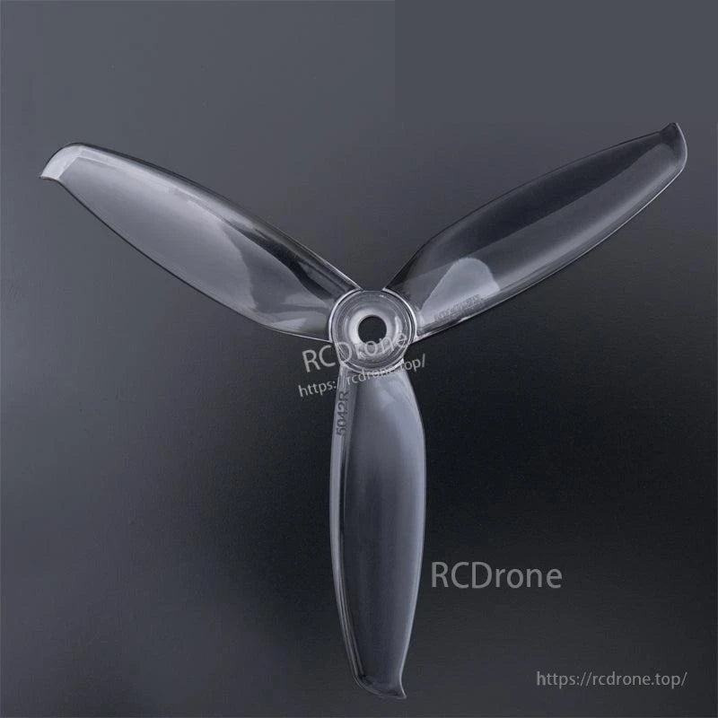 Clear 3-blade drone propeller top view with hub bore visible (watermarked RCDRone)