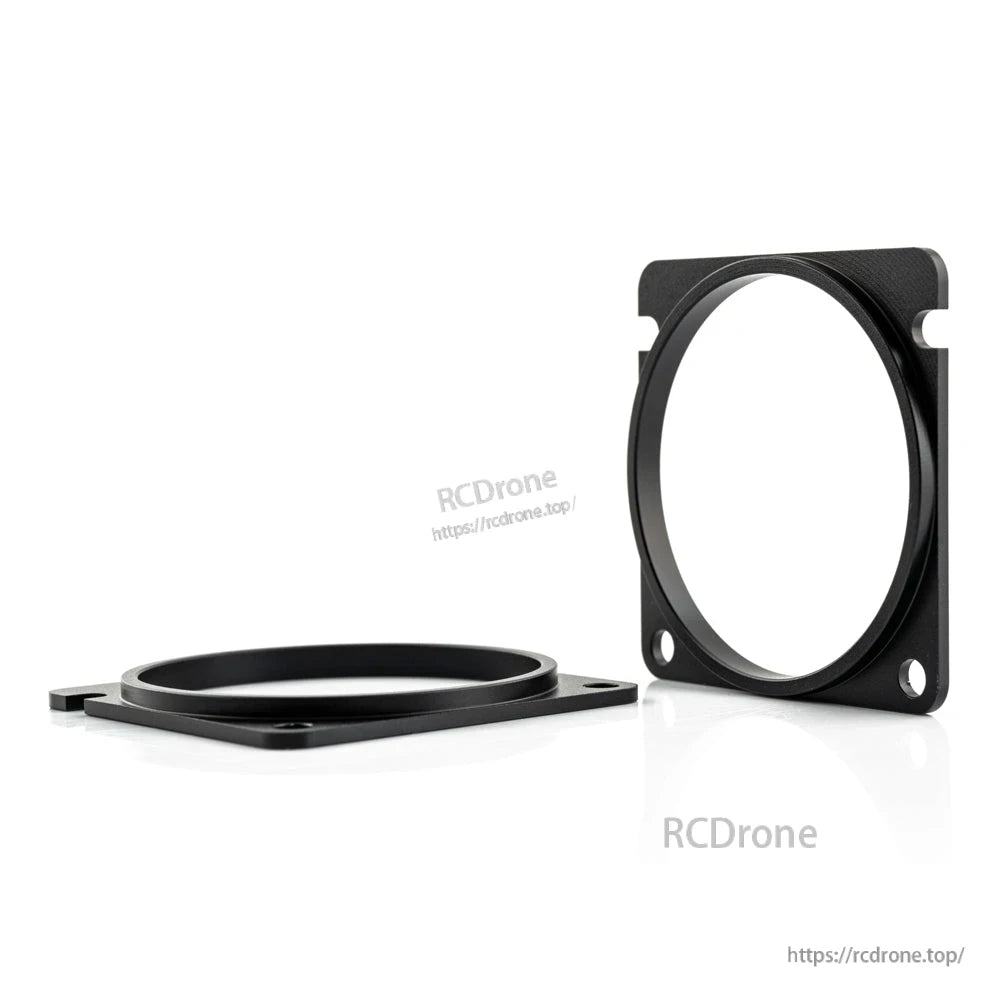 Angled view of two black CNC spacer rings showing thickness and mounting holes