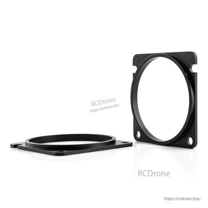 Angled view of two black CNC spacer rings showing thickness and mounting holes
