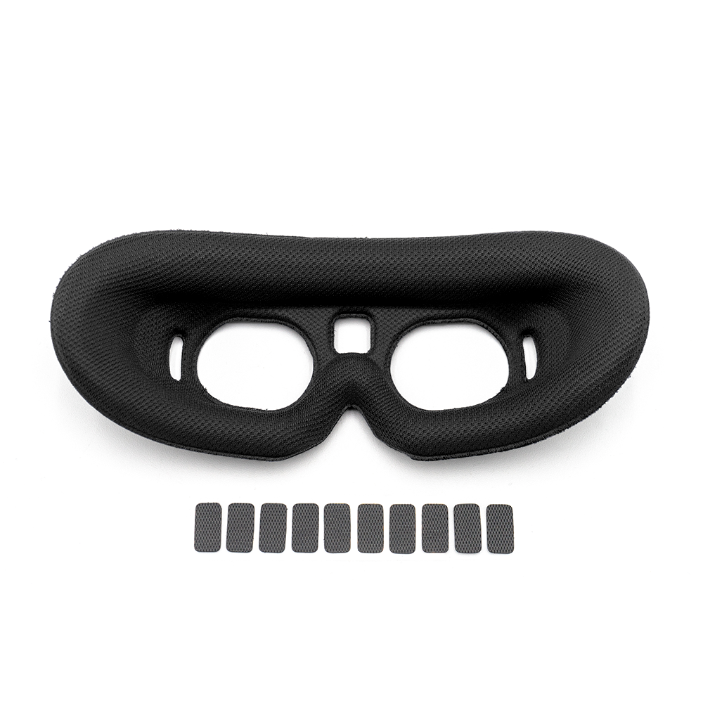 Black lycra foam goggle face pad with nose cutout and 10 adhesive mounting strips
