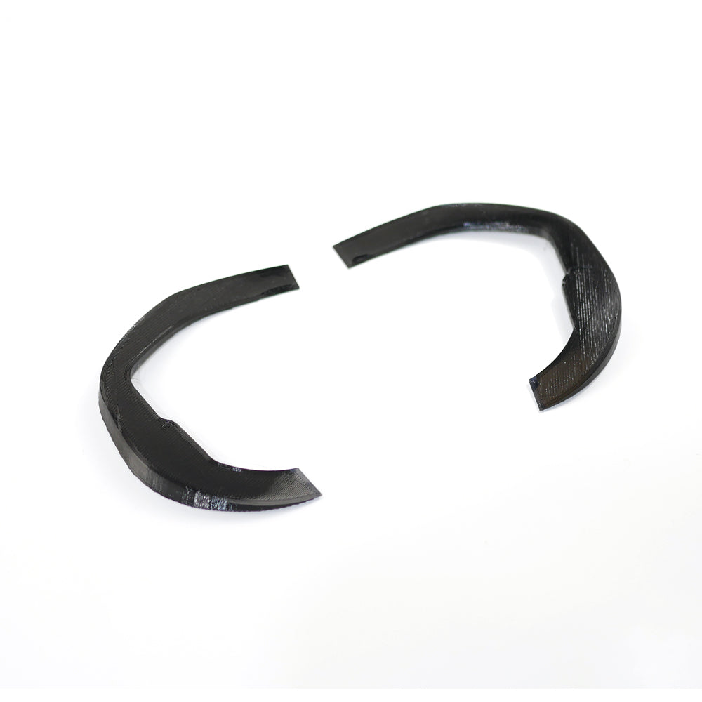Angled view of the 3D-printed curved goggle shim wedges, black plastic pair showing thickness