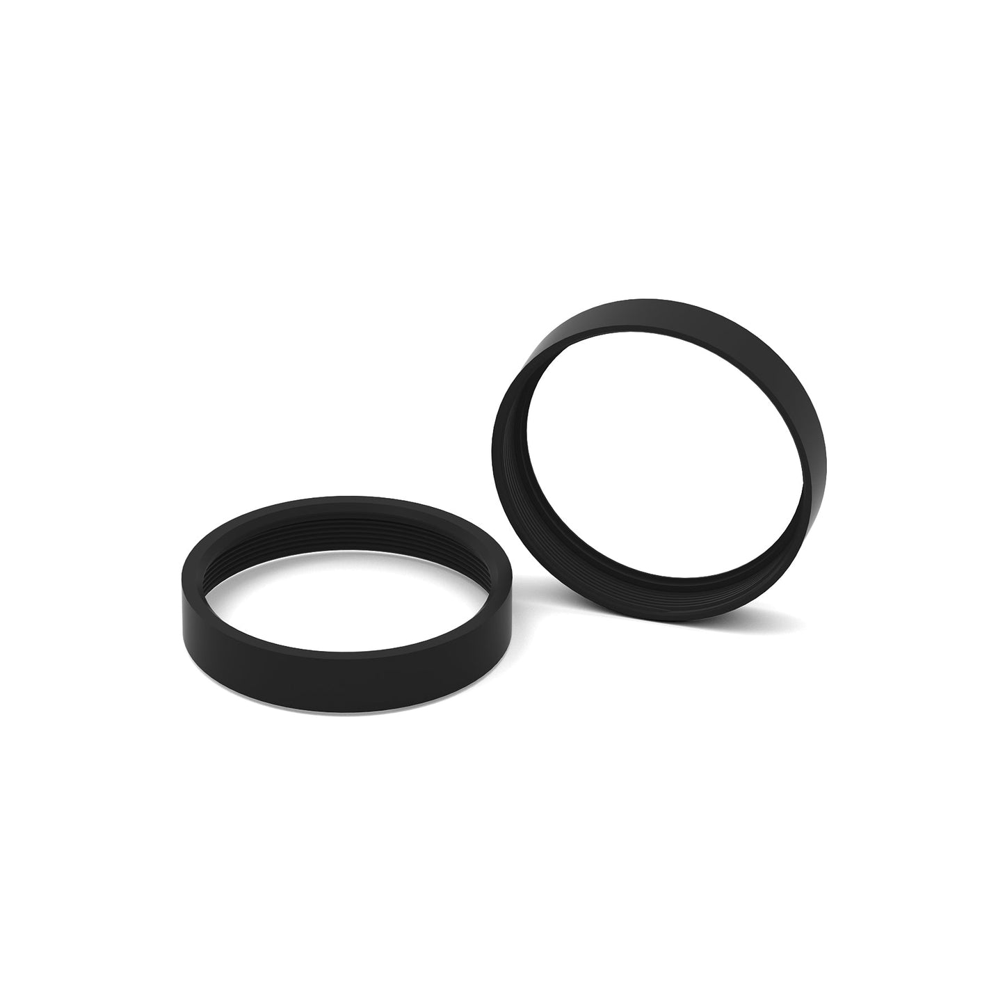 Angle view of two black lens frame rings with visible inner threads on white background