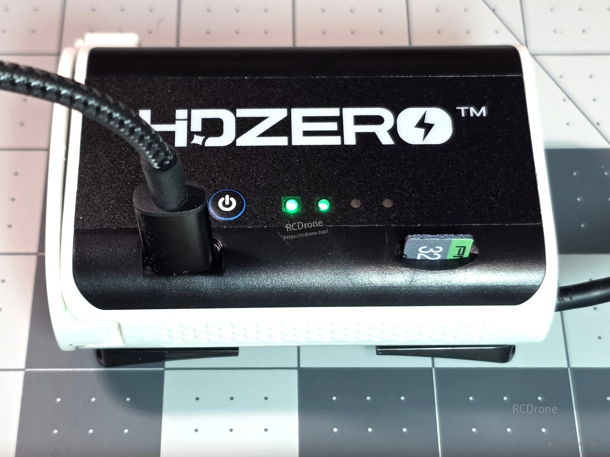 HDZERO receiver module close-up with power button, status LEDs, and cable connected