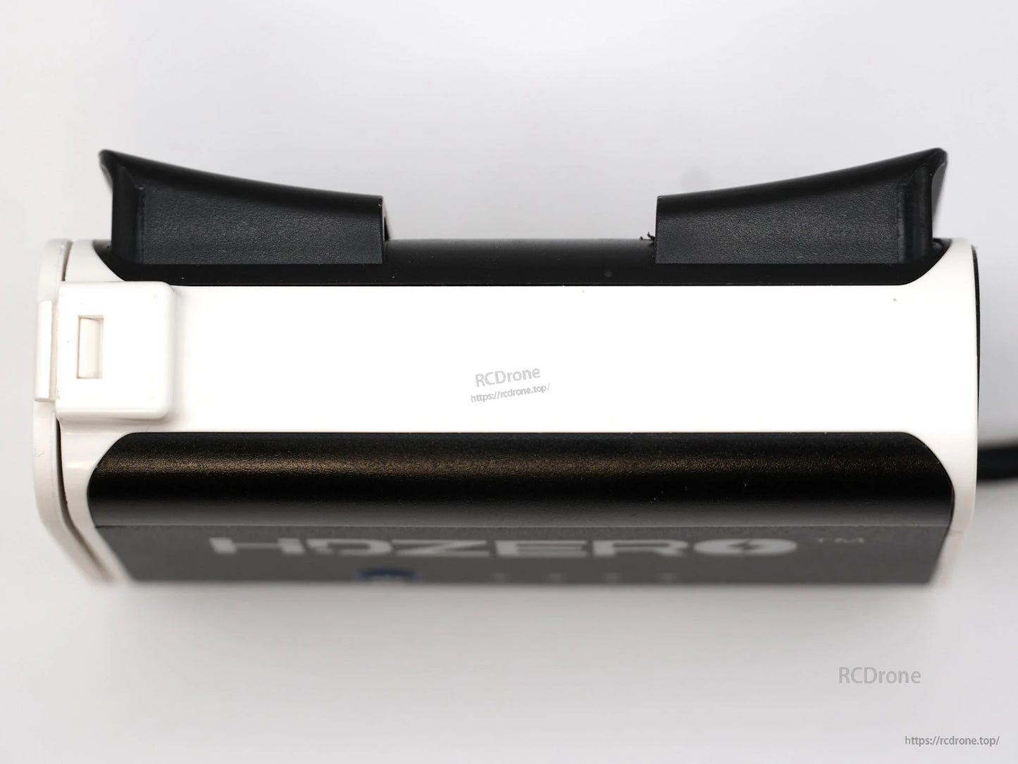 Top/side view of the battery case showing rear strap hooks and white housing profile