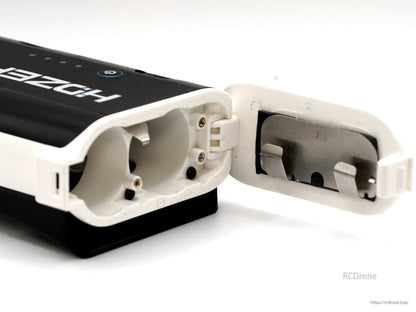 Empty battery case with door open, showing interior slots, hinge, and latch details