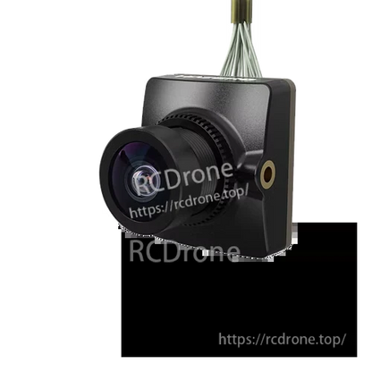 FPV camera close-up with front lens and ribbon cable connection, square housing for whoop builds