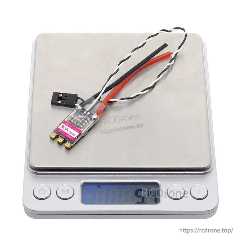 ESC placed on digital scale showing approximate weight around 5.4g with attached wires