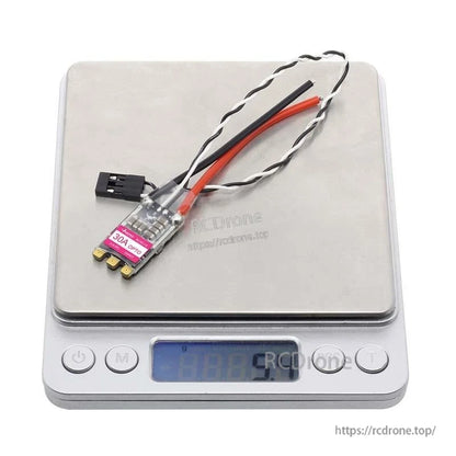 ESC placed on digital scale showing approximate weight around 5.4g with attached wires