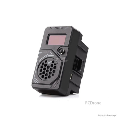 Close-up angled view of ELRS T ONE TX module showing OLED screen, control knob, and side bay