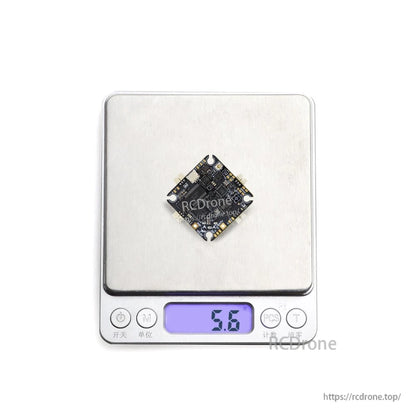 Flight controller shown on digital scale displaying 5.6 g weight