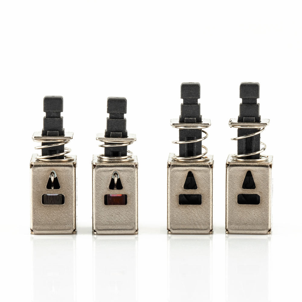Four metal replacement switch modules lined up, front view showing rectangular and triangular cutout slots