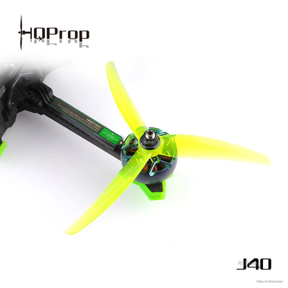 Neon yellow J40 3-blade propeller installed on a quadcopter motor, close-up of hub and blades
