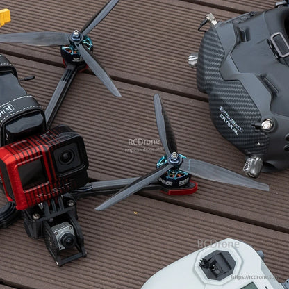 FPV quadcopter with tri-blade propellers installed on motors, close-up with action camera and goggles