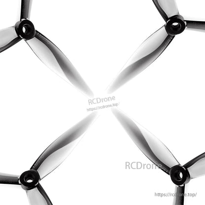 Set of four tri-blade propellers arranged in an X pattern on white background, translucent grey finish