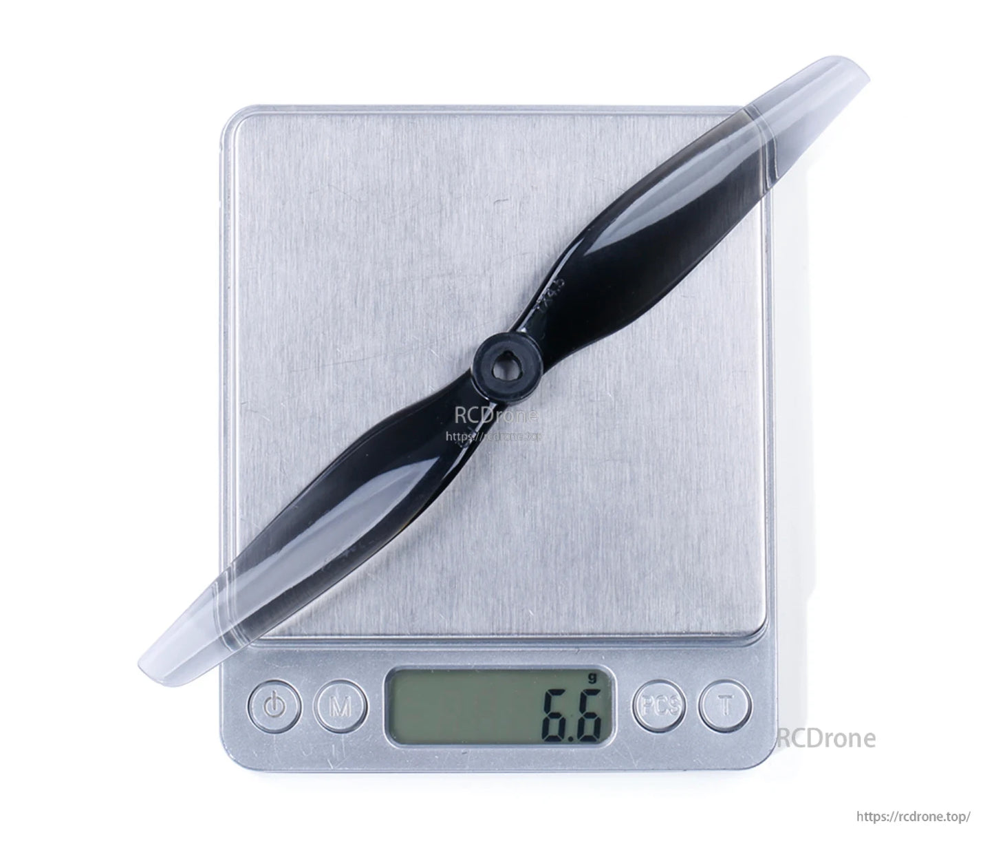 Light grey 7x4.5 propeller placed on digital scale with display reading 6.6