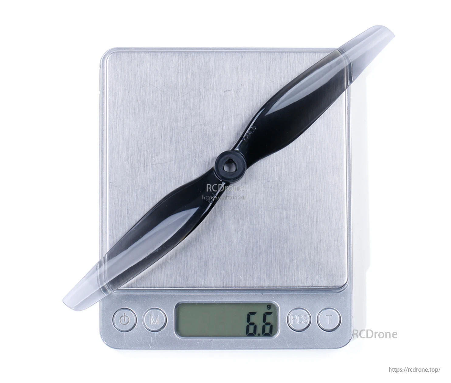 Light grey 7x4.5 propeller placed on digital scale with display reading 6.6