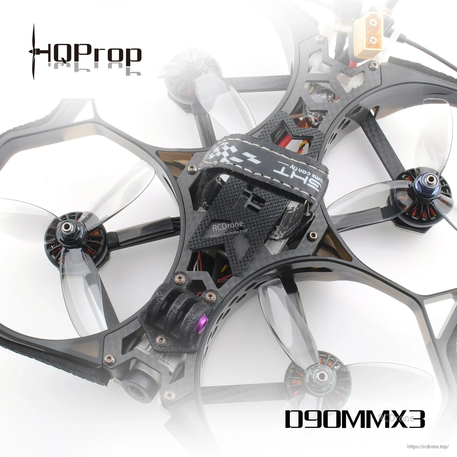 Translucent grey 3-blade props mounted on a ducted cinewhoop quadcopter, top angled view